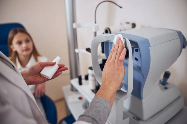 Läkare förbereder speciell anordning för att kontrollera ögonen i optikercentrum — Stockfoto