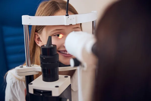Loira caucasiana adolescente menina examinando sua visão na clínica óptica — Fotografia de Stock