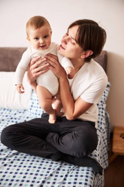 Neşeli genç baba oğluna bakıyor.