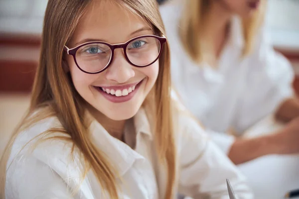 Şirin gülüşlü, genç sarışın bayan çocuk ofisteki en iyi gözlük camını seçiyor. — Stok fotoğraf