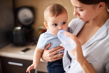 Şişeden su içen aç küçük çocuk.