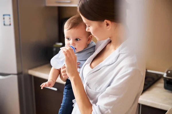 Aandachtige vrouwelijke persoon die naar haar kind kijkt — Stockfoto