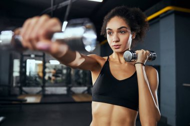 Ağır metal dambılları kaldıran aktif kadın.