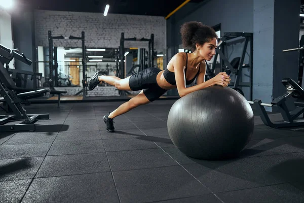 活跃的黑发女人靠在健身球上 — 图库照片
