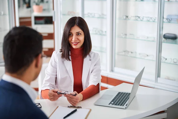 Optometrista femenina mostrando las gafas a su cliente —  Fotos de Stock