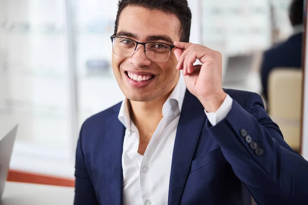 Allegro giovane uomo che tocca i suoi occhiali semi-rimless — Foto Stock