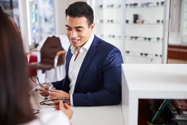 Óptico asesorando a un cliente en la elección de las gafas adecuadas —  Fotos de Stock