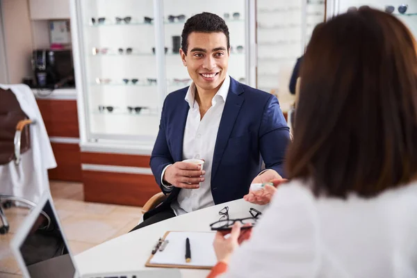 Een tevreden klant wordt geraadpleegd door een ervaren opticien — Stockfoto