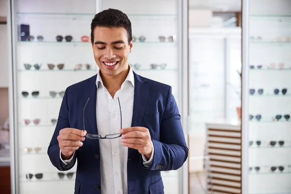 Cliente masculino contento sonriente sosteniendo sus nuevas gafas — Foto de Stock