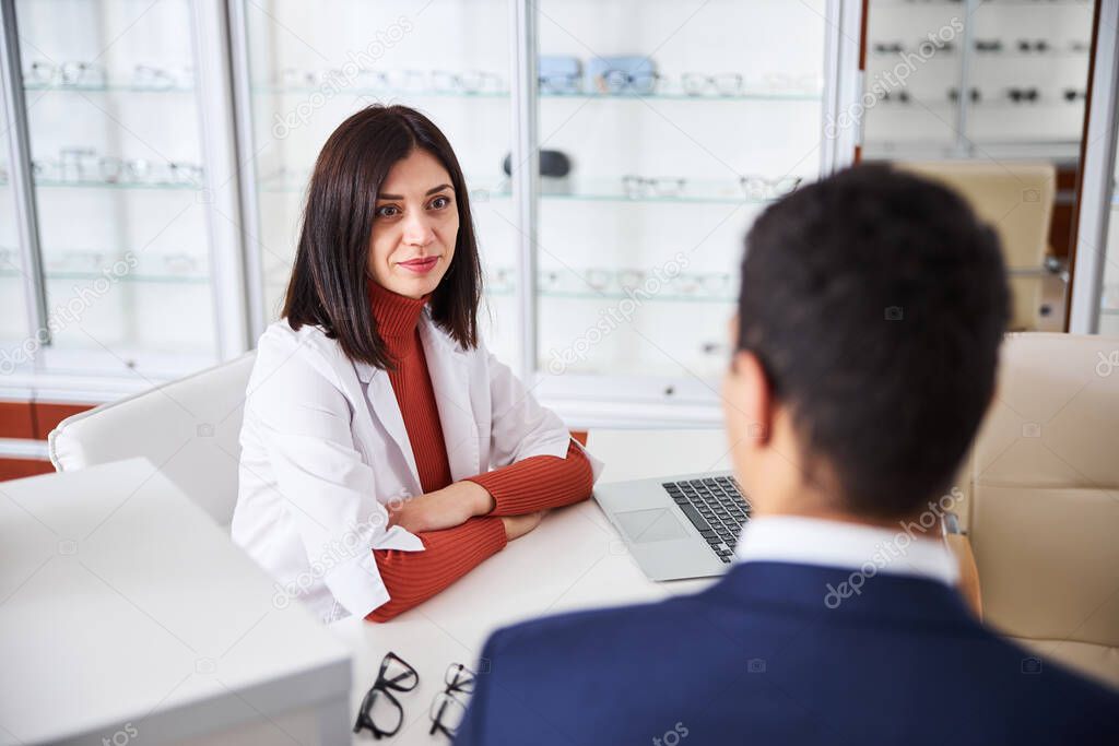 Optician receiving a male client in her office