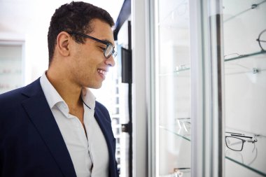 Gülümseyen müşteri yeni bir gözlük seçiyor.