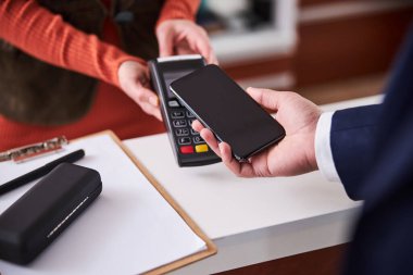 Müşteri cep telefonuyla ödeme yapıyor.