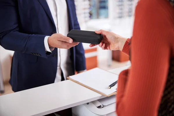 Young man buying a pair of spectacles — Stock Photo, Image