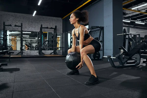 Mujer morena seria trabajando en su cuerpo deportivo — Foto de Stock