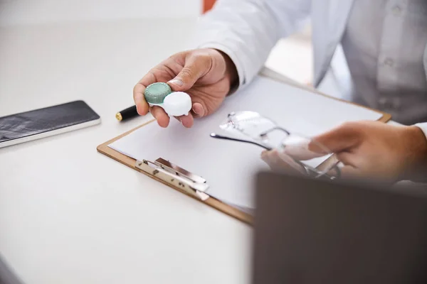 Optician masculino com contatos e óculos sentados na mesa — Fotografia de Stock