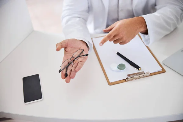 Optometrist zeigt eine neue halbrandlose Brille — Stockfoto