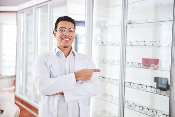 Glimlachend optisch adviseur in bril vooruit kijkend — Stockfoto