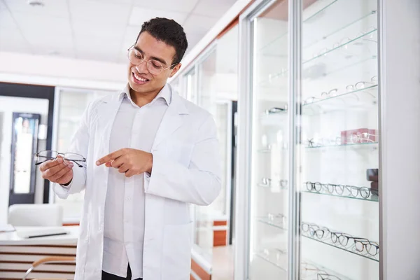 Aantrekkelijke mannelijke opticien die nieuwe glazen op recept demonstreert — Stockfoto