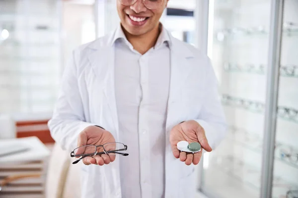 Glimlachende optometrist biedt contacten en glazen aan kopers — Stockfoto