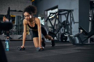 Genç esmer kadın fiziksel antrenman yapıyor.