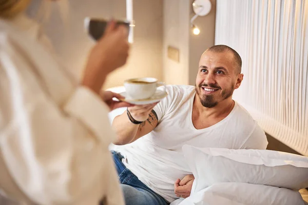 Agradável homem casado sendo servido café na cama — Fotografia de Stock