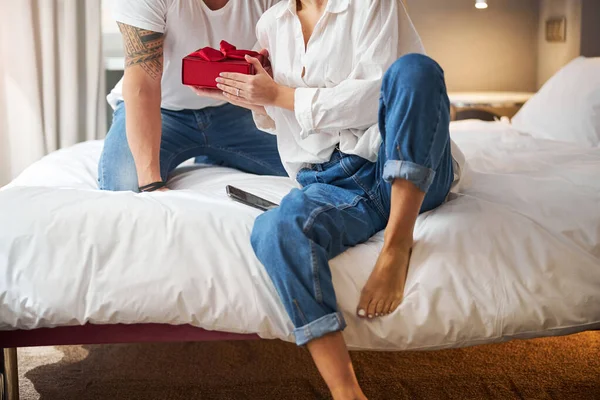 Frau erhält ein Geburtstagsgeschenk, das mit einem Seidenband gebunden ist — Stockfoto