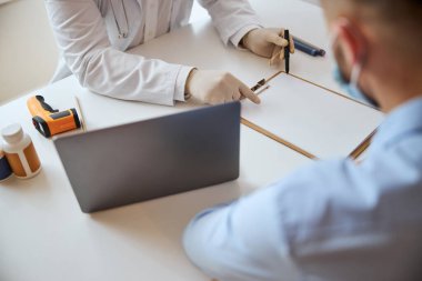 Doktor kabinesindeki adam için beyaz liste gösteren modern zeki terapist.