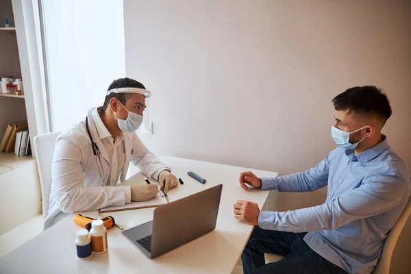 Doctor dialogando con el paciente en el consultorio médico — Foto de Stock