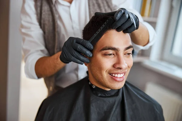 Frisör gör frisyr med borstning i manlig salong — Stockfoto