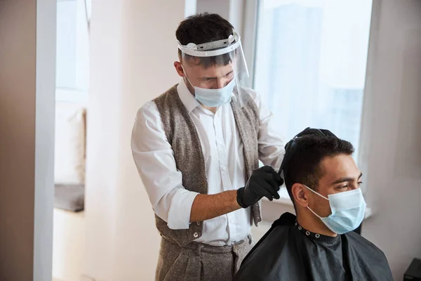 Indický samec v ochranné masce tráví čas v salonu krásy, takže vlasy stříhat — Stock fotografie
