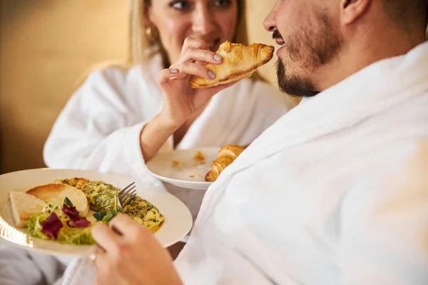 Caring woman feeding her husband with breakfast — Stock Photo, Image