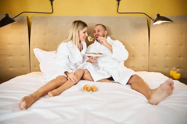 Amado marido tratando sua esposa com um pedaço de omelete — Fotografia de Stock