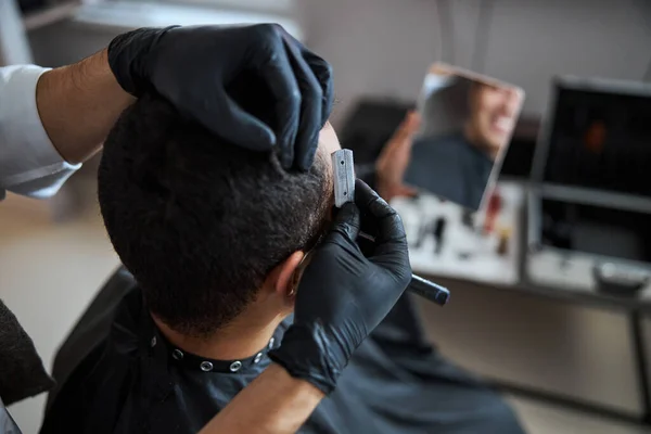 Чистый мужчина в черном пеньюаре, парикмахерская в салоне красоты — стоковое фото