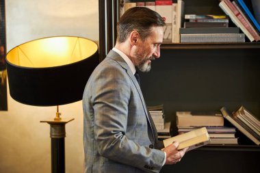 Otelde kitap seçen meraklı bir adam var.