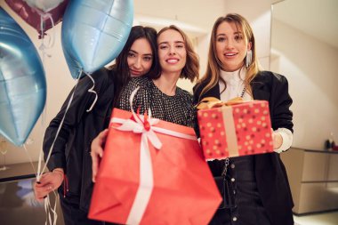 Güzel bayan ve misafirleri kameraya gülümsüyor.