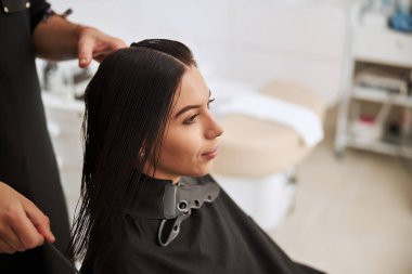 Müşteri saç stili üzerinde çalışan profesyonel bir kuaför.