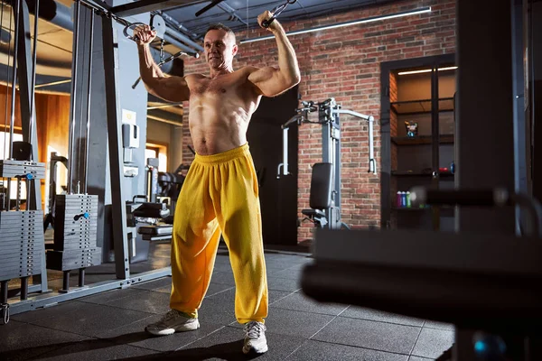 Glädjande manlig kroppsbyggare tränar på gym — Stockfoto