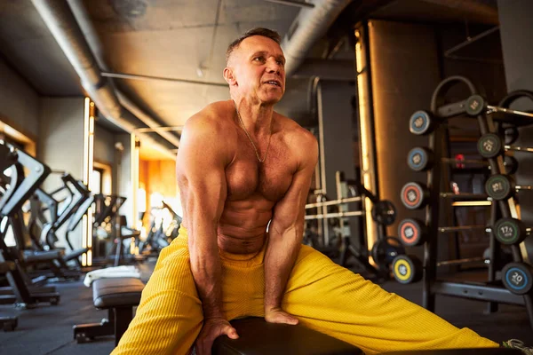 Fokuserad man tränar och använder gym bänk — Stockfoto