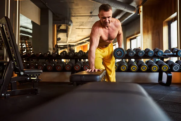 Seriöser Sportler bei seinem Trainingsprogramm im Fitnessstudio — Stockfoto