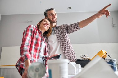 İşçi, akıllı telefonuyla kadın eşine bir şey gösteriyor.