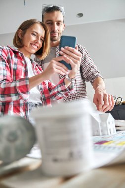 İki genç inşaat mühendisi iş yerinde selfie çekiyor.