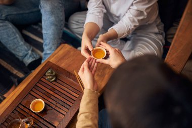 Erkek el, kafede kadına çay veriyor.