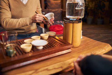 Genç adam kafede geleneksel çay seremonisi yapıyor.