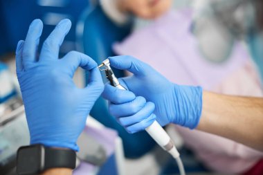 Elleri hastane eldivenlerinde ama diş matkabından çıkartıyorlar.