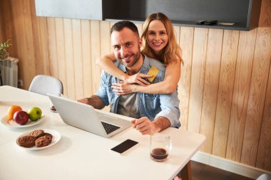 Evde dizüstü bilgisayar kullanan güzel bir çift.