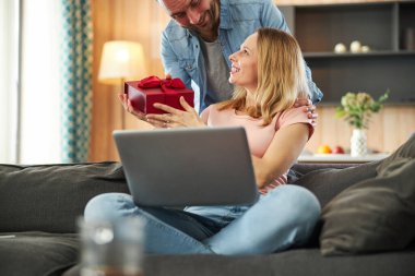 Evde kocasından hediye kabul eden hoş bir kadın.