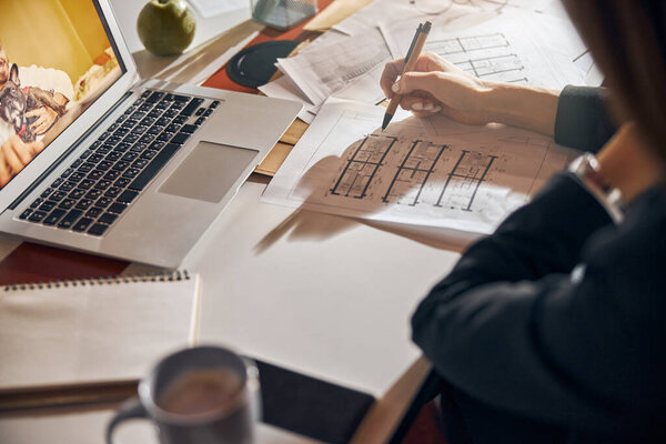 Архитектор вносит коррективы в план дома шариковой ручкой