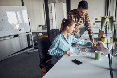Mühendis ve iş arkadaşı teknik bir çizim yapıyor.