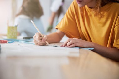 Dikiş atölyesinde kıyafet çizen kadın çocuk