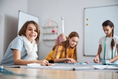 Dikiş atölyesinde çalışan neşeli kadın çocuklar.